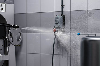 Water jet from a high-pressure cleaner hits the DUOi wall mounted receptacle