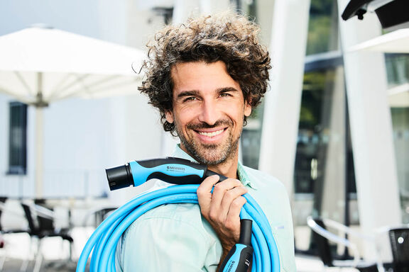 Mann mit MENNEKES Ladekabel Typ 2 Mode 3