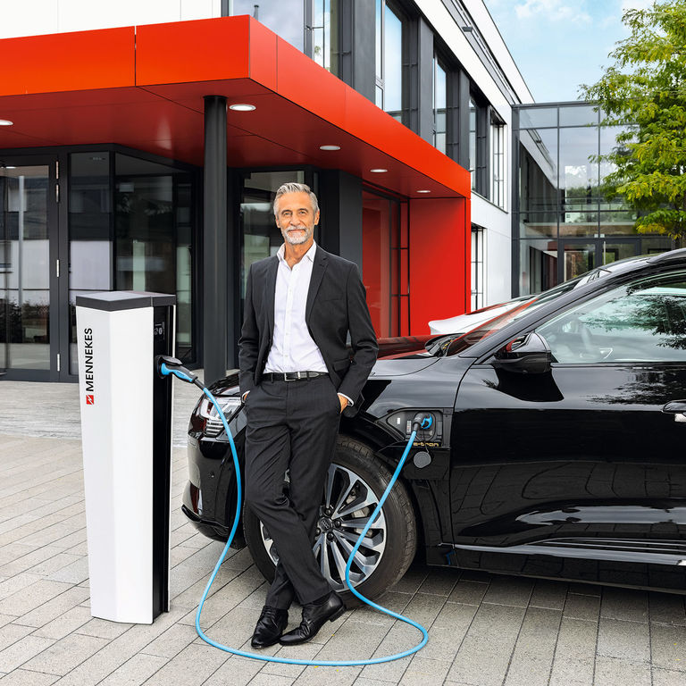 Geschäftsmann lädt sein E-Auto an einer MENNEKES Ladesäule