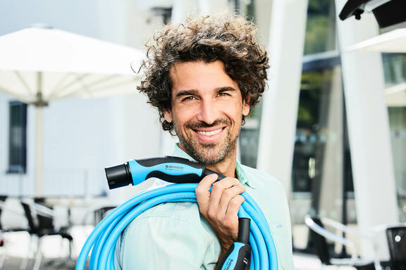 Mann mit MENNEKES Ladekabel Typ 2 Mode 3